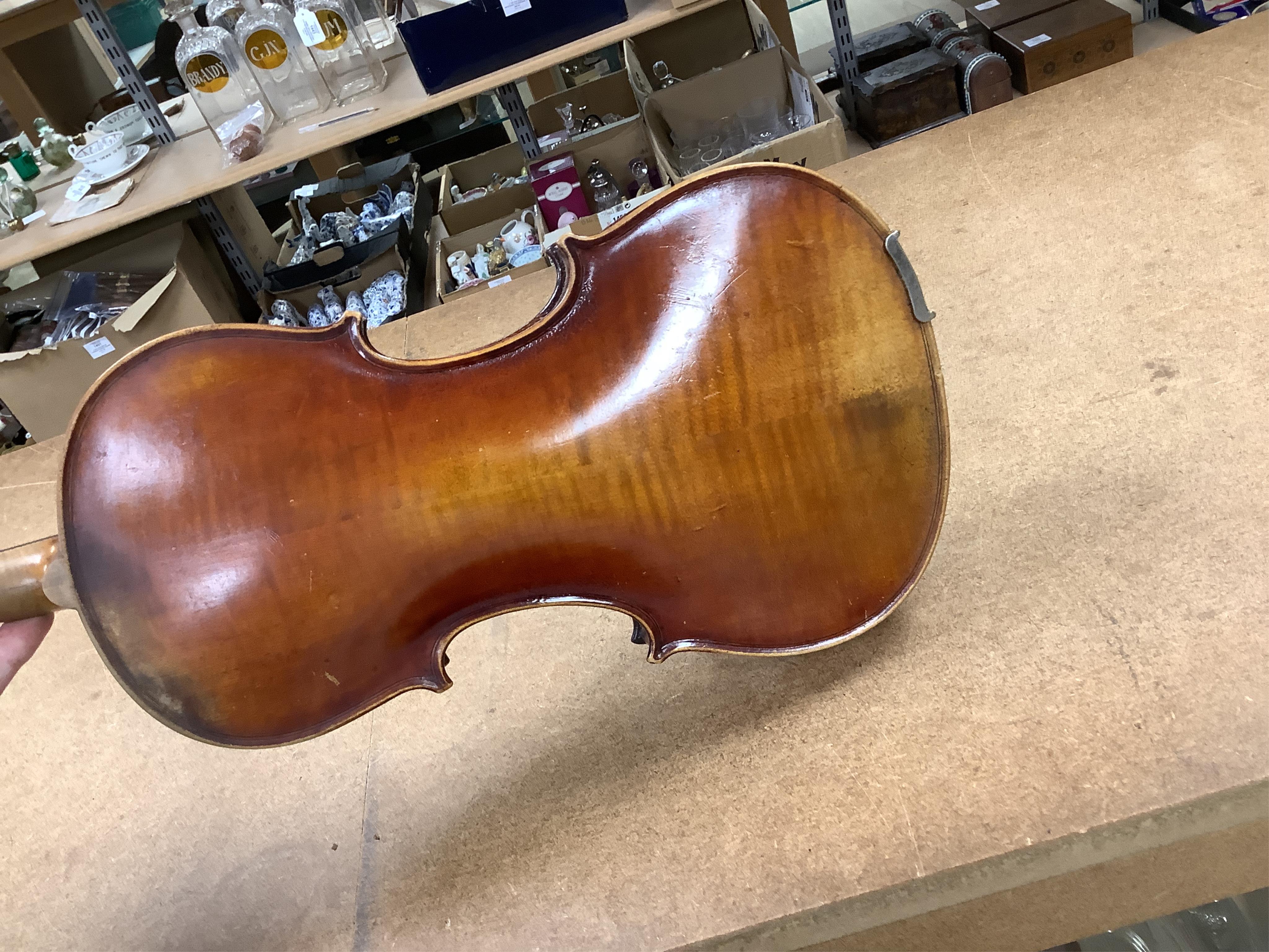 An early 20th century cased violin and cover, 60cm long